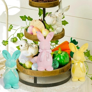 Détail de figurines lapins de Pâques en vert, rose et jaune avec nœuds en soie