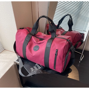 Macro shot of fuchsia nylon travel bag featuring dual handles and side zipper detail
