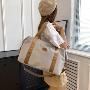Sac de voyage beige à grande capacité avec bandoulière marron en situation réelle