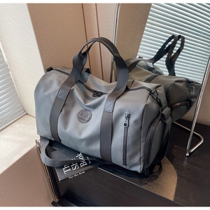 Detail of grey nylon travel bag showing reinforced handles and side zipper compartment