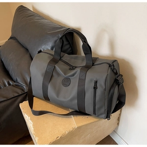 Macro detail of dark grey nylon travel bag with waterproof texture and logo plaque