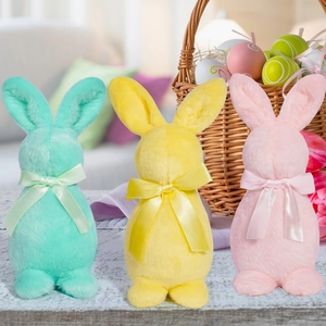 Trois figurines de lapin de Pâques en peluche avec nœuds satinés en décor printanier