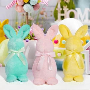 Gros plan des figurines de lapins de Pâques en couleurs pastel avec nœuds en satin