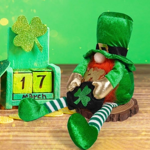 Macro view of St. Patrick's Day gnome doll sitting on wood with clover calendar