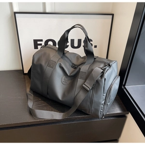 Detail of waterproof charcoal nylon travel bag with shoe compartment and shoulder strap