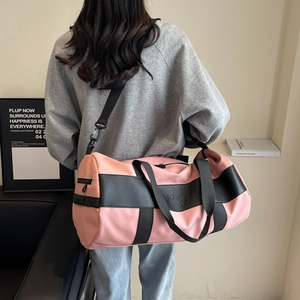 Pink and black nylon duffel bag for travel, featuring a modern cylindrical design