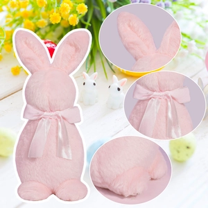 Lapin de Pâques en peluche rose avec nœud en soie sur fond de jardin festif et lumineux