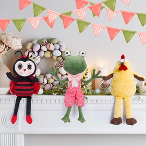 Three plush Easter animals including a chick and frog displayed on a white fireplace