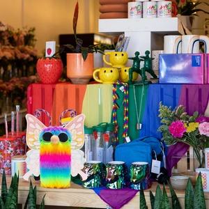 Detailed close-up of a rainbow plush butterfly with sunglasses in a gift display