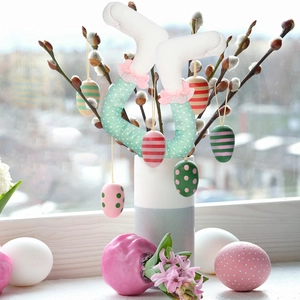 Detailed view of polka dot Easter bunny legs with colorful hanging eggs and flower decor