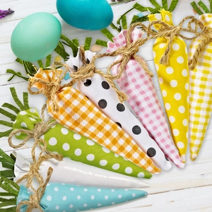Detail of 8 Easter fabric carrots with plaid and polka dot patterns on white wood
