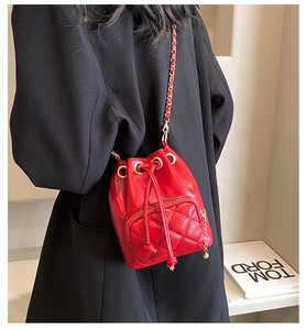 Détail du mini sac seau rouge avec poche matelassée et bandoulière en chaîne dorée
