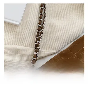 Close-up of the silver metal chain and brown PU leather strap with visible stitching
