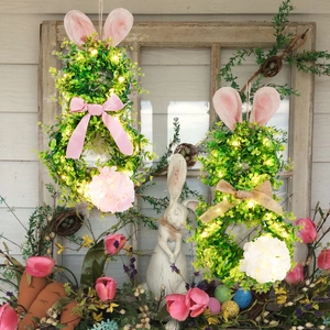 Detailed view of LED bunny wreaths with green foliage, silk bows and floral accents