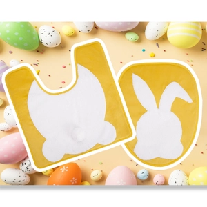 Detailed view of yellow Easter bathroom mat set featuring white rabbit silhouettes and eggs