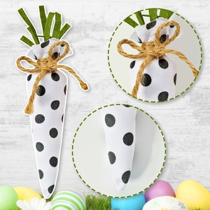 Detail of fabric Easter carrot with black polka dots, green felt leaves and jute twine