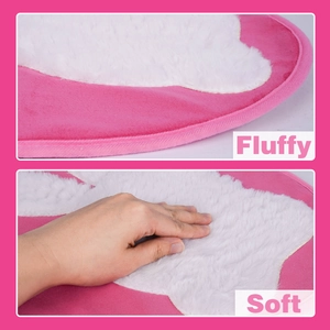 Close-up of soft pink and white plush toilet mat with fluffy texture and thick edges