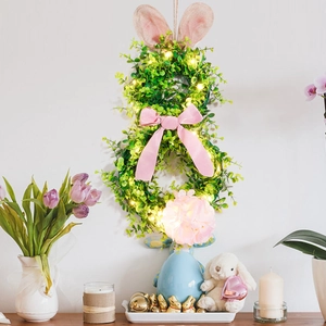 Detail of light-up Easter bunny wreath with faux green leaves and pink floral accents