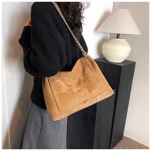 Detail of vintage quilted tote bag with matte finish and chain shoulder strap on model