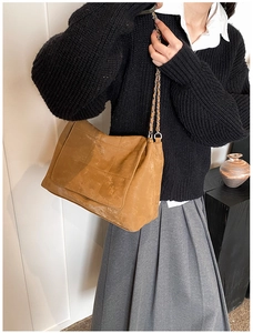 Detail of vintage brown tote bag with quilted stitching and leather chain shoulder strap