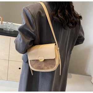 Sacoche selle rétro beige et marron portée sur un blazer gris montrant la taille réelle