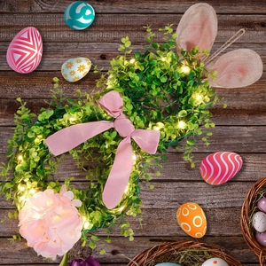 Macro detail of Easter bunny wreath with warm LED lights and pink bow on rustic wood