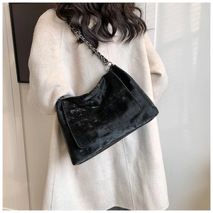 Detail of vintage black tote bag with quilted texture and silver chain strap