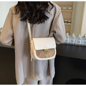 Sac à bandoulière minimaliste en cuir crème et motif marbre marron porté par le mannequin