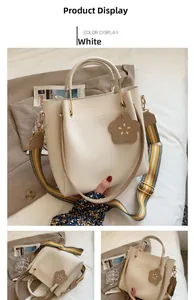 Detail of white PU tote bag with floral charm and striped woven shoulder strap