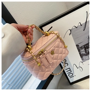 Detailed shot of pink quilted crossbody bag with gold chain and floral metal clasp