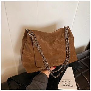 Detail of vintage brown quilted tote bag with silver chain strap for daily commute