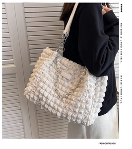 Close-up of cream white bubble texture tote bag with pearl and silver chain strap details