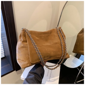 Detailed view of brown quilted tote with vintage texture and silver chain strap