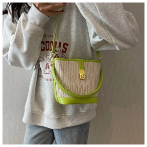 Detail of green faux leather trim and woven straw texture on the summer bucket bag