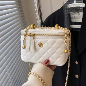 White quilted crossbody bucket bag with gold chain strap and camellia ornament