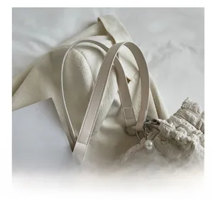 Detail of cream bubble texture handbag with large pearl beads and dual handles