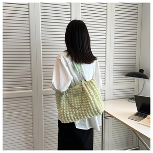 Detail of light green cloud tote bag featuring bubble texture and pearl chain strap