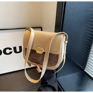 Détail du sac selle rétro avec cuir beige, velours côtelé marron et boucle dorée