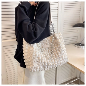 Close-up of white bubble texture tote bag featuring pearl strap and metal chain detail