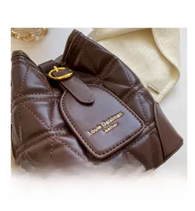 Close-up of dark brown quilted leather bucket bag with elegant gold metal hardware
