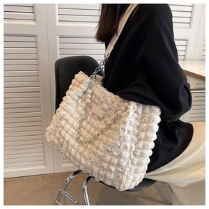 Detail of white bubble pleated tote bag with pearl chain and wide fabric strap