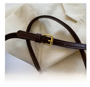 Close-up of adjustable golden buckle and premium dark brown leather strap detail