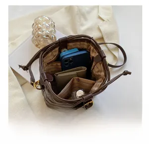 Interior view of brown quilted bucket bag showing storage capacity for phone and wallet