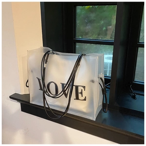 Detail of frosted PVC tote bag featuring black LOVE print and faux leather shoulder strap