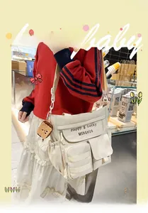 Detail of off-white multi-pocket oxford tote bag with cute toast plush charm and branding