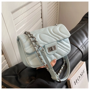 Detail of light blue quilted leather bag showing silver chain strap and metal turn lock