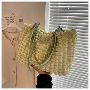 Detail of light green popcorn texture tote bag with pearl flower chain and leather strap