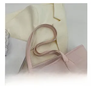 Detail of pink crocodile embossed tote bag featuring fine gold LOVE lettering