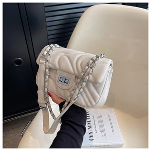 Detail of off-white quilted crossbody bag with silver chain and metal square clasp
