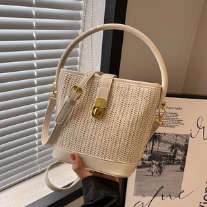 Elegant beige woven straw bucket bag with leather trim and gold buckle for women